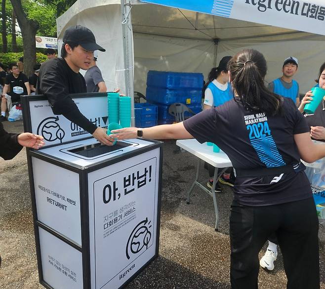 28일 서울하프마라톤에서 한 10km 완주자가 다회용컵으로 물을 마신 뒤 이를 반납하고 있다. /박강현 기자