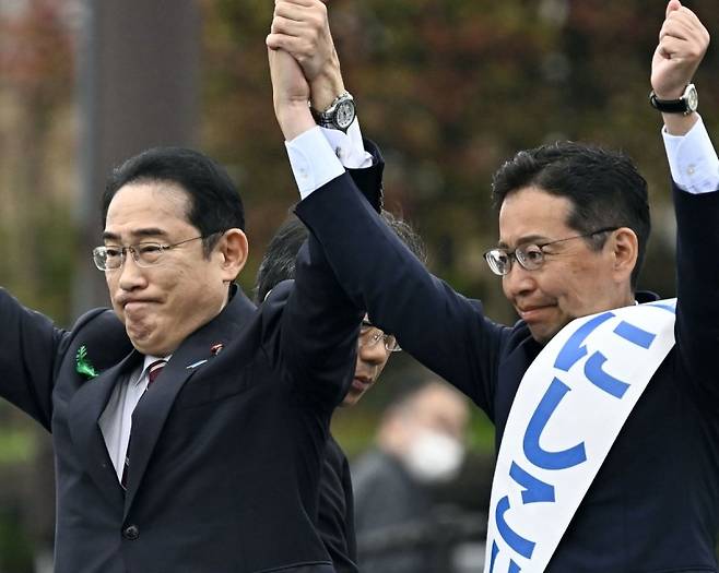 기시다 후미오 일본 총리(왼쪽)가 지난 21일 시마네현을 찾아가 보궐선거에 출마한 자민당 후보와 함께 팔을 번쩍 들어올리고 있다. 연합뉴스
