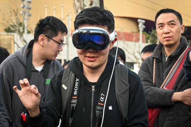 중국의 한 애플 기기 이용자가 3월 중국 상하이에서 열린 새 애플 스토어 개장 행사에 '비전 프로'를 착용한 채 참석하고 있다. 상하이=AFP 연합뉴스