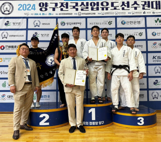 2024 양구 전국실업유도선수권대회 남자 단체전서 대회 2연패를 달성하며 시즌 3관왕에 오른 양평군청 선수단이 우승기를 앞세우고 기념촬영을 하고 있다.양평군청 제공