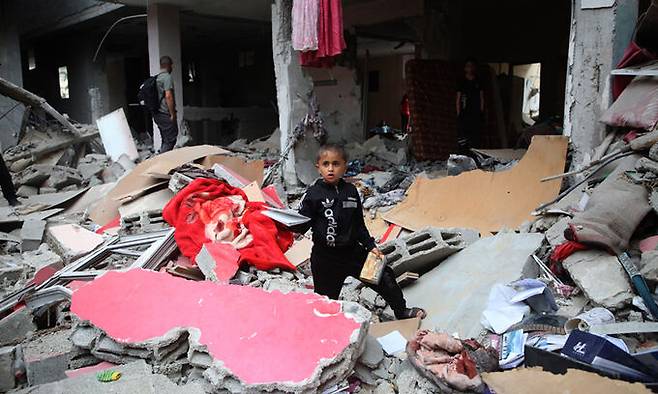 27일(현지시간) 가자지구 내 라파의 이스라엘의 공습으로 인해 무너진 건물에 한 아이가 서 있다. 신화연합뉴스