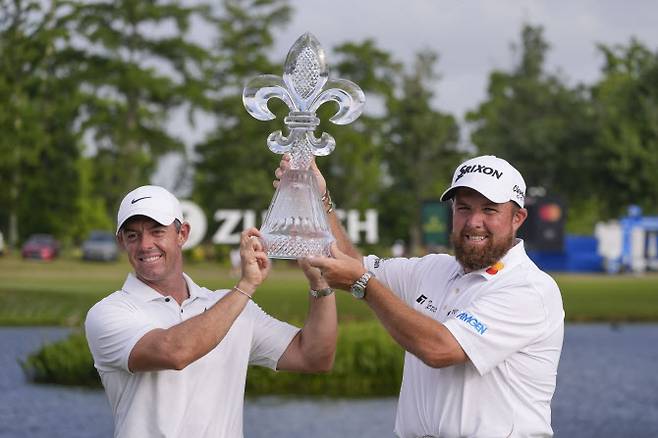 왼쪽부터 로리 매킬로이와 셰인 라우리가 29일 미국 루이지애나주 TPC 루이지애나에서 열린 PGA 투어 취리히 클래식에서 우승한 뒤, 우승 트로피를 함께 들며 활짝 웃고 있다.(사진=AP/뉴시스)