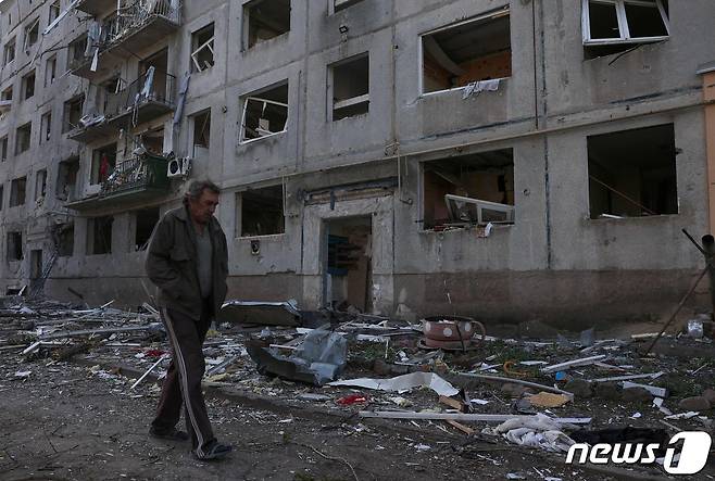 지난 15일(현지시간) 우크라이나 도네츠크주 아우디이우카 인근의 오케레틴 마을에서 한 남성이 포격과 공습으로 파괴된 주택 옆을 지나가는 모습. 2024.04.15/ ⓒ AFP=뉴스1 ⓒ News1 권진영 기자