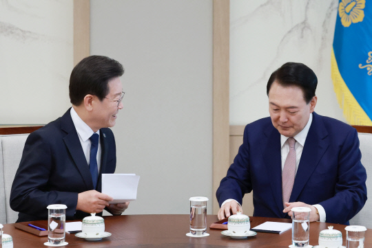 이재명 더불어민주당 대표가 29일 서울 용산 대통령실 집무실에서 열린 윤석열 대통령과의 영수회담에서 미리 준비해 온 메시지를 품에서 꺼낸 뒤 윤 대통령과 대화하고 있다.<연합뉴스>