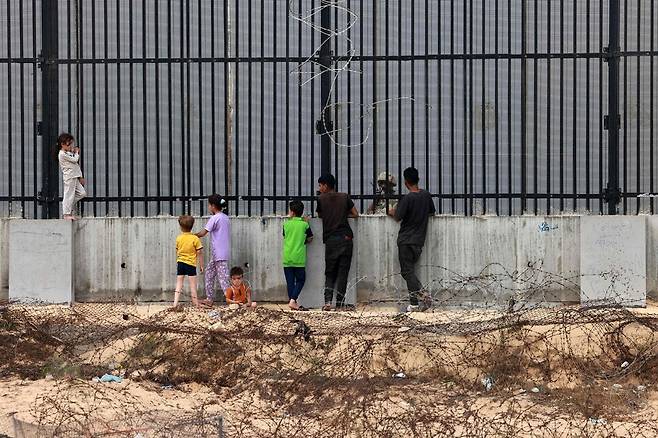 지난 26일(현지시각) 팔레스타인 아이들이 가자지구 최남단 라파흐와 맞닿은 이집트 국경 앞에서 서성이고 있다. 라파흐/AFP 연합뉴스