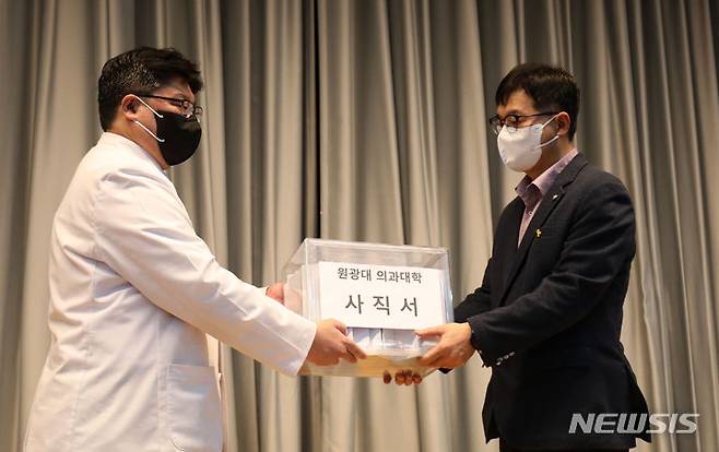 [익산=뉴시스] 김얼 기자 = 강홍제(왼쪽) 원광대학교병원 비상대책위원회 위원장이 29일 전북 익산시 원광대학교병원 대강당에서 의대 학장에게 의료진들이 제출한 사직서를 전달하고 있다. 2024.04.29. pmkeul@newsis.com