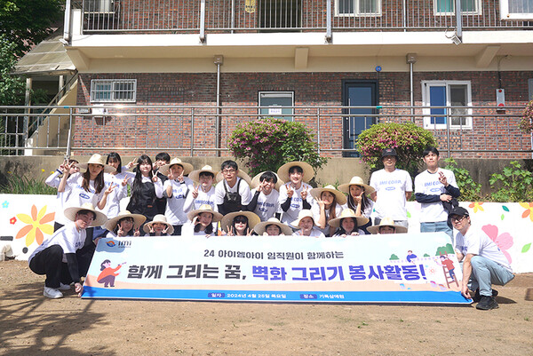 아이엠아이 임직원들이 벽화 그리기 봉사활동 성료 후 기념 사진을 촬영하고 있다. 사진제공 = 아이엠아이