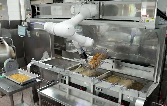 두산로보틱스 협동로봇이 단체급식 튀김작업을 수행하고 있다. [사진제공=두산로보틱스]