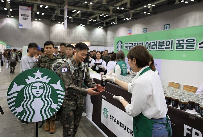 국군장병 취업박람회의 스타벅스 음료 제공 부스에서 파트너에게 아이스 커피를 받는 장병의 모습. /스타벅스 제공
