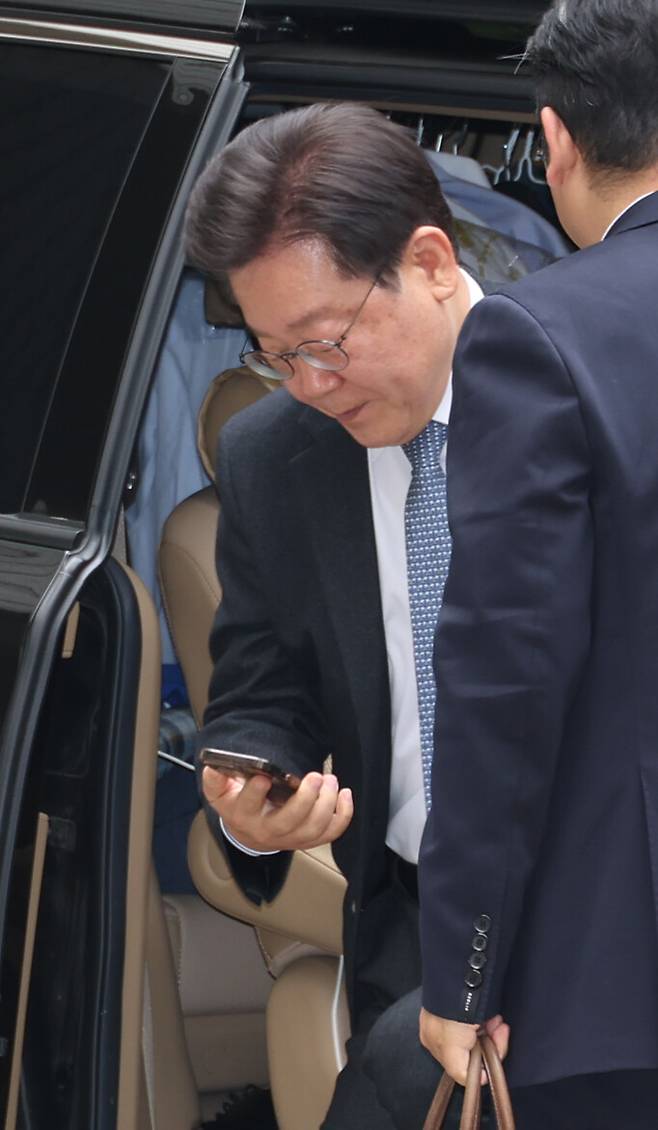 이재명 더불어민주당 대표가 서울중앙지방법원에 출석하며 핸드폰 화면을 보고 있다. 김혜윤 기자