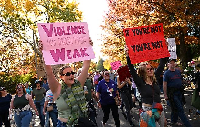 28일(현지시간) 호주 캔버라에서 여성 폭력 근절을 위한 정부 행동을 촉구하는 집회에 참석한 시민들이 팻말을 들고 행진하고 있다. EPA연합뉴스