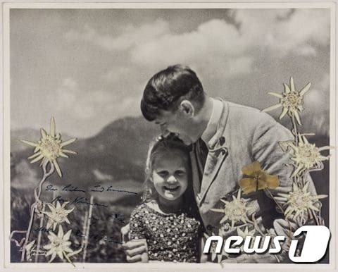 히틀러와 지도자의 아이 로사 베르닐레 니에나우로가 찍힌 사진./출처=CNN 캡처
