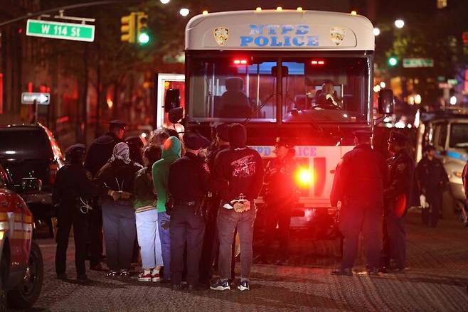 30일 밤 뉴욕 경찰이 체포돼 손이 뒤로 묶인 학생들을 경찰 버스에 태우고 있다. 뉴욕/AFP 연합뉴스