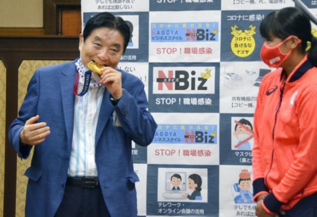 가와무라 다카시(왼쪽) 일본 나고야 시장이 2021년 8월 4일 나고야시청을 방문한 도쿄올림픽 소프트볼 금메달리스트 고토 미우의 메달을 양해도 구하지 않은 채 깨물고 있다. 나고야=로이터 연합뉴스