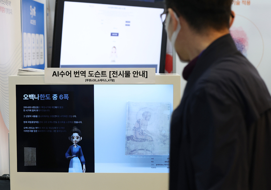 A visitor looks at an electronic screen displaying an AI-powered sign language translator at AI Expo Korea 2024 at Coex in southern Seoul on Wednesday. [YONHAP]