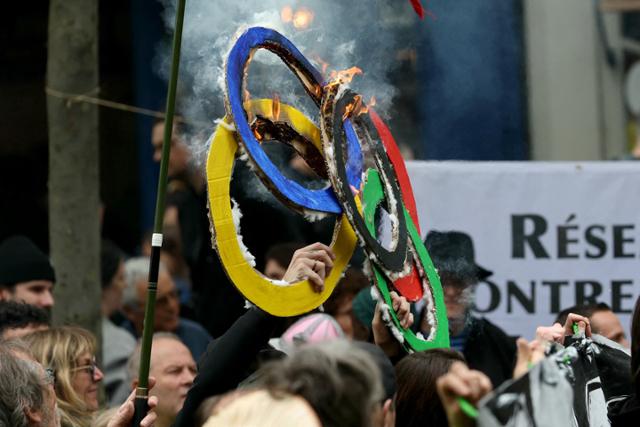노동절인 1일 프랑스 파리에서 일부 시위대가 종이로 만든 올림픽 오륜을 불태우고 있다. 파리=AFP 연합뉴스