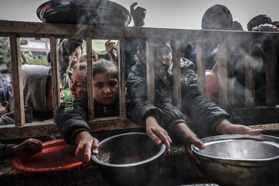 이스라엘과 무장 단체 하마스 간의 전투가 진행 중인 가운데, 팔레스타인 난민 어린이들이 남부 가자 지구의 라파에 있는 한 정부 학교에 있는 음식을 받기 위해 모인다. AFP=연합뉴스