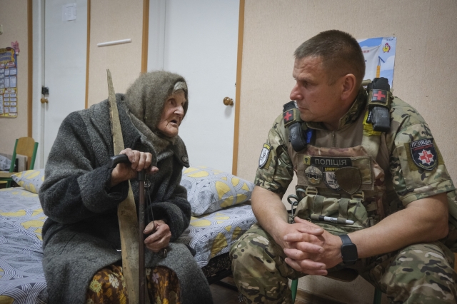 홀로 10km를 걸어 점령지를 탈출한 리디아 스테파니우나 로미코우스카 할머니가 우크라이나 군인과 얘기를 나누고 있다. AP연합뉴스