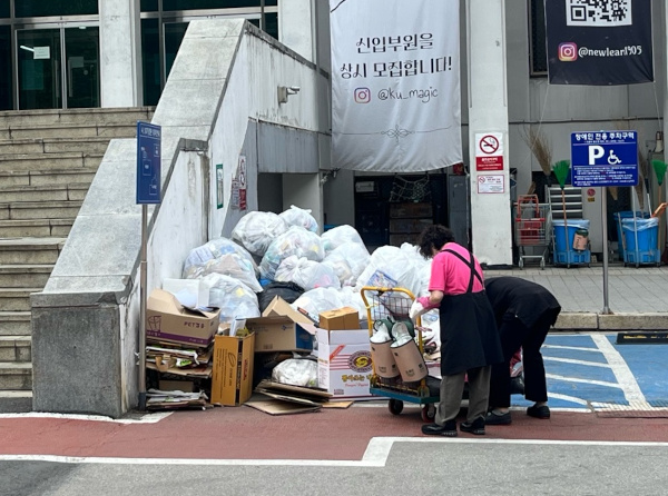 1일 서울 성북구 고려대학교 대학원 중앙도서관 건물 앞에서 한 미화 노동자가 쓰레기 더미를 정리하고 있다.