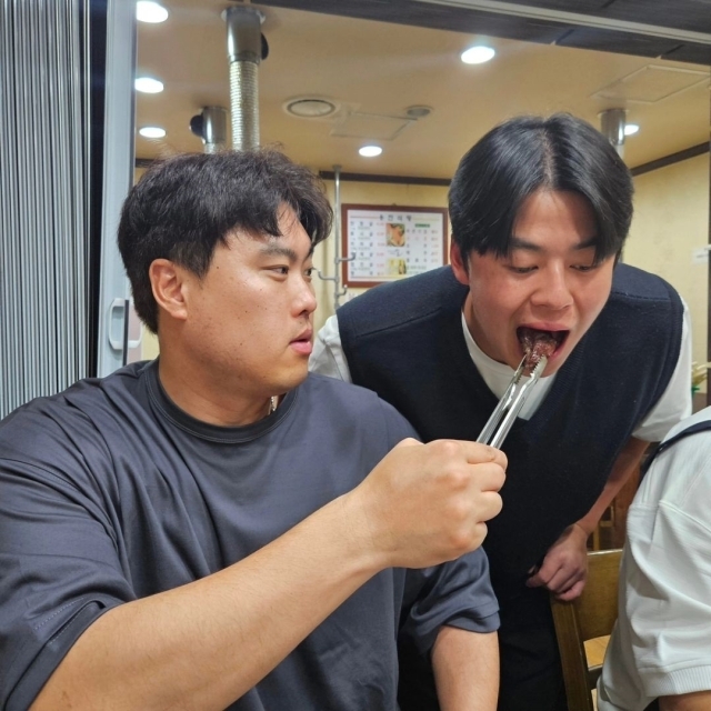 한화 이글스 류현진이 노시환에게 소고기를 먹여주고 있다./99코퍼레이션