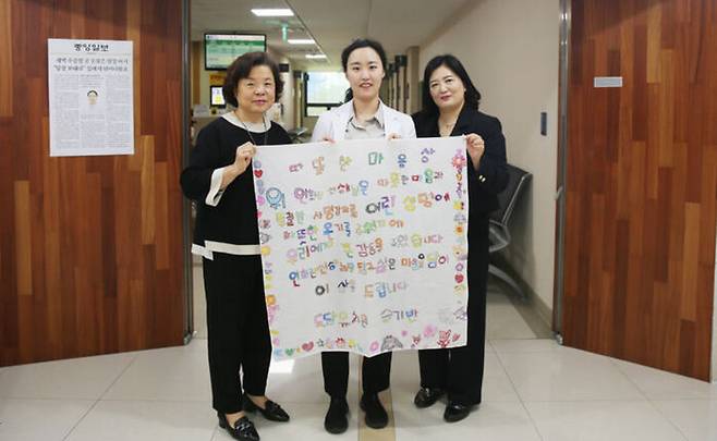 도담유치원 황인애 원장(왼쪽)이 건양대병원 연희진 교수(가운데)에게 아이들이 만든 감사장을 전달하고 있다. (사진=건양대학교병원 제공)