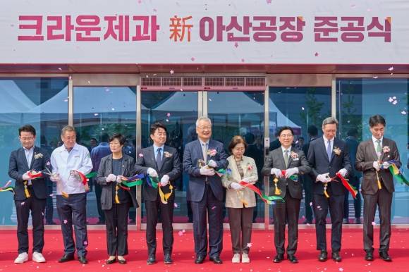 윤영달(왼쪽 다섯 번째) 크라운해태제과 회장이 지난달 30일 충남 아산시 음봉면의 스낵 전문 공장인 신(新)아산공장 준공식에서 윤석빈(여덟 번째) 크라운제과 대표, 강훈식(네 번째) 국회의원, 박경귀(일곱 번째) 아산시장과 함께 테이프 커팅을 하고 있다. 크라운제과 제공