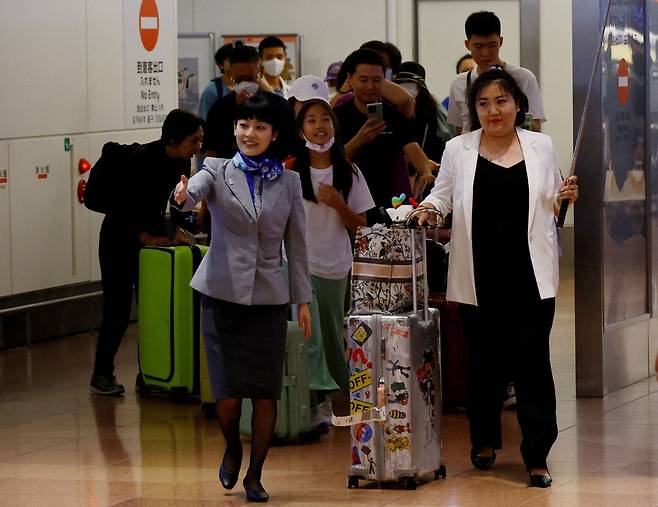 일본 도쿄 하네다 공항에 도착한 중국 여행단을 일본 항공사 직원이 안내하고 있다. /로이터