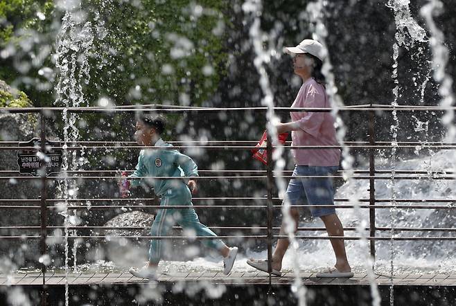 초여름 날씨가 이어진 3일 오후 경기 안산시 상록구 노적봉폭포에서 시민들이 시원하게 떨어지는 물줄기 사이로 지나가고 있다. /뉴스1