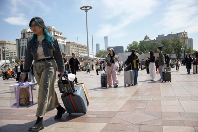중국 노동절 연휴가 시작된 1일 중국인 여행객들이 대형 가방을 끌고 베이징역을 향하고 있다. 베이징=EPA 연합뉴스