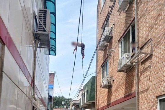 지난 1일 오전 11시 24분쯤 충북 청주 흥덕구의 한 주택단지에서 우즈베키스탄 국적의 40대 여성이 6m 높이의 전깃줄에 매달려 있는 모습. 뉴시스