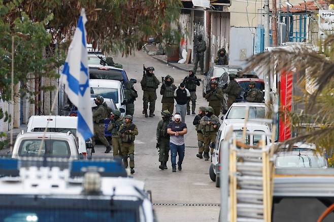 이스라엘군이 요르단강 서안지구에서 팔레스타인인 2명의 눈을 가리고 손을 묶은 채 끌고 가고 있다. /사진=로이터