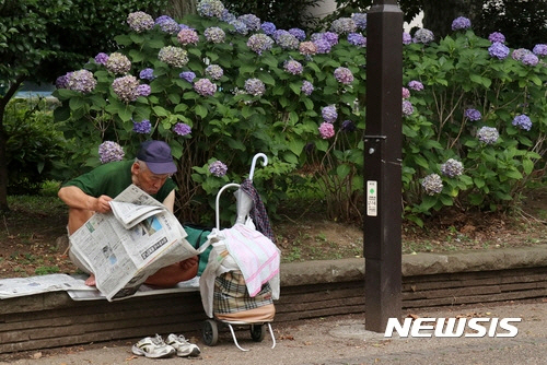 일본 도쿄 우에노 공원에서 2017년 7월 5일 한 노인이 신문을 읽고 있다.AP뉴시스