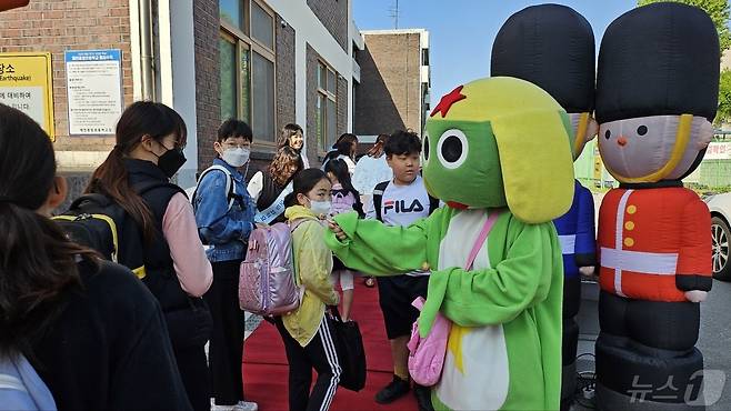 만화 캐릭터 분장을 한 제천 중앙초등학교 학부모회원들이 등굣실 학생들에게 막대사탕을 나눠주고 있다.(학부모회 제공)2024.5.4/뉴스1