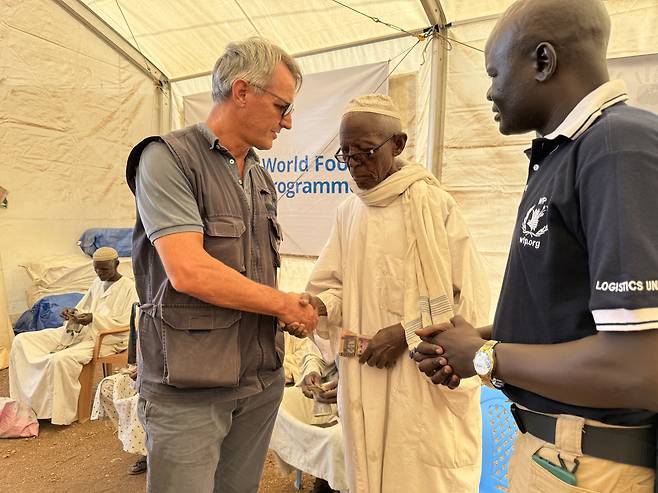 지난 2월 15일 유엔식량계획(WFP) 마이클 던포드(왼쪽) 동아프리카 지역 본부장이 수단 피난민들과 이야기를 나누고 있다./WFP