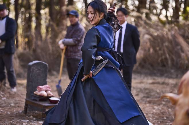 A shaman played by actor Kim Go-eun performs a ritual in “Exhuma.” (Showbox)