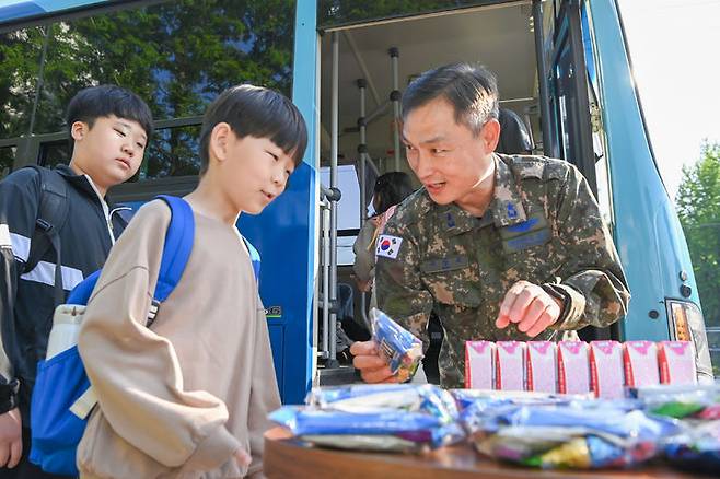 [대구=뉴시스] 구상모 공군 11전투비행단장이 통학버스에 오르는 군 자녀들에게 간식을 전달하고 있다. (사진=공군 제11전투비행단 제공) 2024.05.04. photo@newsis.com *재판매 및 DB 금지