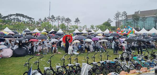 어린이날인 5일 충북 청주시 생명누리공원에서 많은 나들이객이 우산을 쓰고 공연을 관람하고 있다.