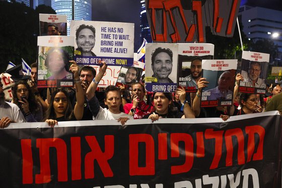 4일 이스라엘 해안 도시 텔아비브에서 팔레스타인 무장세력에 포로로 잡힌 이스라엘 인질들의 석방을 요구하는 시위가 열린 가운데 시위자들이 인질들의 초상화를 들고 있다. AFP=연합뉴스