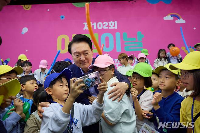 [서울=뉴시스]윤석열 대통령이 5일 청와대 연무관에서 열린 제102회 어린이날 초청행사에서 퇴장하며 어린이들과 사진을 찍고 있다. (사진=대통령실 제공) 2024.05.05. photo@newsis.com