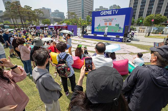 서울 시민들이 광화문광장 육조마당에 개최된 지니 TV 팝업에서 ‘시네마 콘서트’를 즐기는 모습