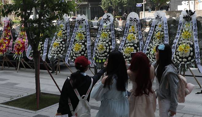 3일 서울 용산구 하이브 사옥 정문 앞 인도에 하이브를 규탄하는 내용을 담은 근조화환 30개가 설치되어 있는 가운데 BTS 팬들이 현장을 방문해 인증 사진을 찍고 있다. 이는 BTS가 악성 루머에 휘말리는 가운데 하이브의 미온한 대처에 분노한 BTS 팬들이 진행하는 집회의 일환으로,  지난 3일부터 7일까지 하이브 정문 앞에 근조화환이 설치될 예정이라고 한다./ 고운호 기자
