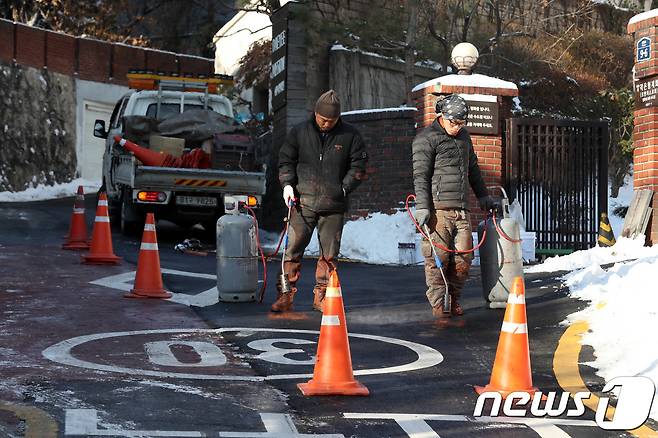 2017년 서울 성북구의 한 이면도로에서 성북구 관계자들이 낙상 사고 예방을 위해 얼음을 녹이는 모습. ⓒ News1 박세연 기자