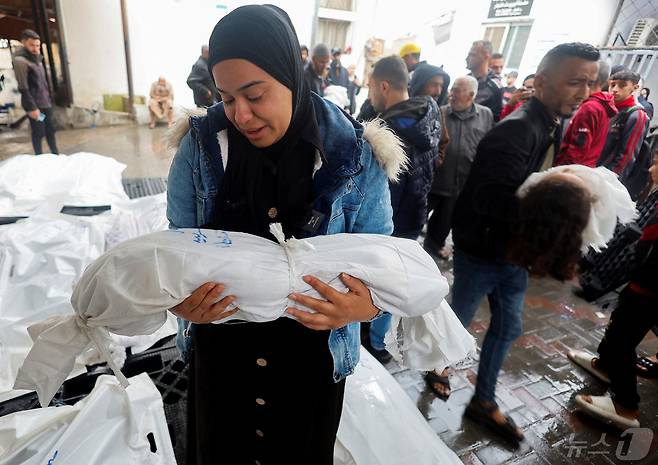 라파 지역에서 이스라엘 공습으로 희생된 어린이를 껴안고 울고 있는 여성. ⓒ 로이터=뉴스1 ⓒ News1 박형기 기자