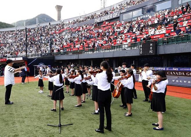 롯데백화점 '키즈 오케스트라'가 지난해 9월 사직 야구장에서 애국가를 연주하고 있다.