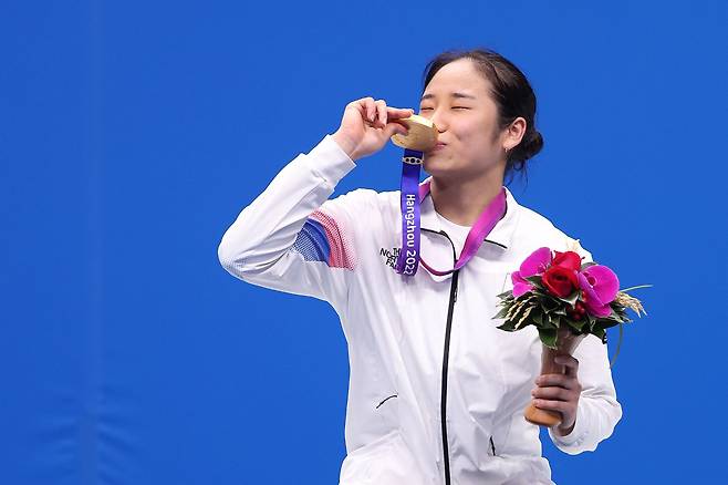 안세영이 작년 항저우 아시안게임 배드민턴 여자 단식 메달 수여식에서 금메달에 키스하는 모습. /뉴스1