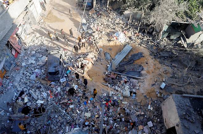 8일(현지시간) 가자지구 최남단 도시 라파에서 피란민들이 이스라엘군의 공습으로 파괴된 주택의 잔해를 살피고 있다. 로이터연합뉴스