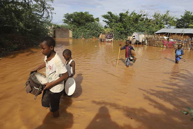 지난달 28일(현지시간) 케냐 타나강과 인접한 모로로 지역에서 홍수가 발생한 뒤 아이들이 물에 잠긴 마을을 벗어나고 있다. AP연합뉴스