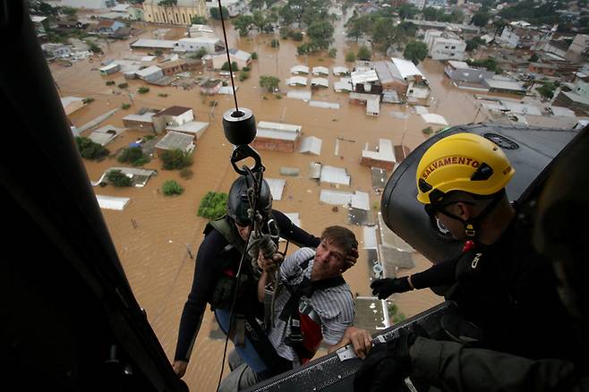 지난 4일(현지시간) 브라질 히우그란지두술주 카노아스에서 홍수가 발생한 후 한 남성이 군 소방관들에 의해 구조되고 있다. 로이터연합뉴스