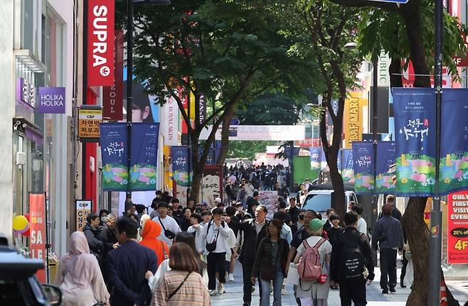 8일 서울 중구 명동에 위치한 패션 브랜드 매장 앞에 여행 가방을 든 외국인들이 몰려들고 있다. 명동 상권은 코로나19 사태 기간 외국인 입국이 막히면서 공실률이 치솟았으나 최근 K패션 열풍이 불면서 활기를 되찾고 있다. [한주형 기자]