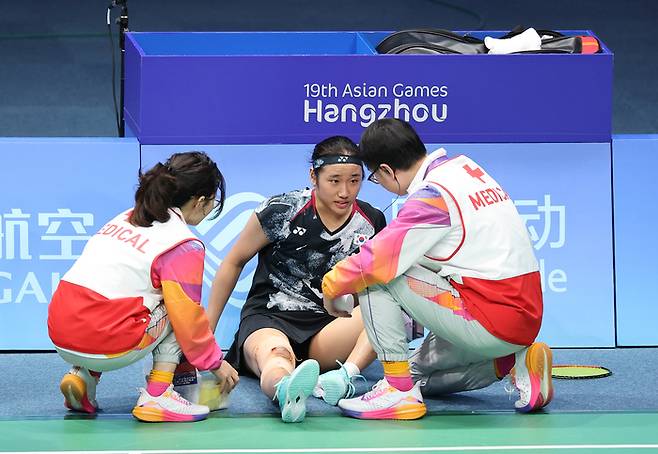 안세영이 지난해 10월 항저우 아시안게임 배드민턴 여자단식 결승전에서 무릎 통증으로 트레이너의 확인을 받고 있다. 연합뉴스